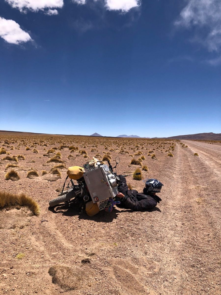 Motorradfahrer auf Motorradreise in Südamerika nach Sturz auf sandiger Schotterpiste mit Reiseenduro in Kolumbien