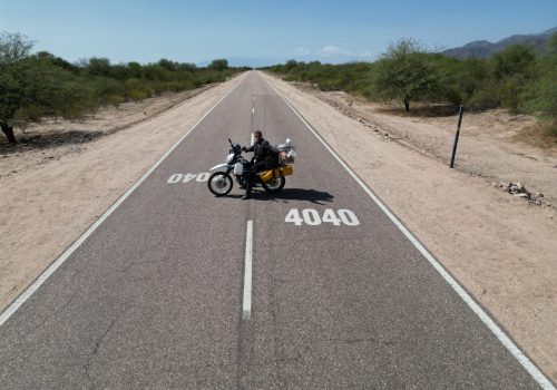 Motorradfahrer auf Ruta 40 in Argentinien auf endloser Straße während Motorradreise durch Südamerika