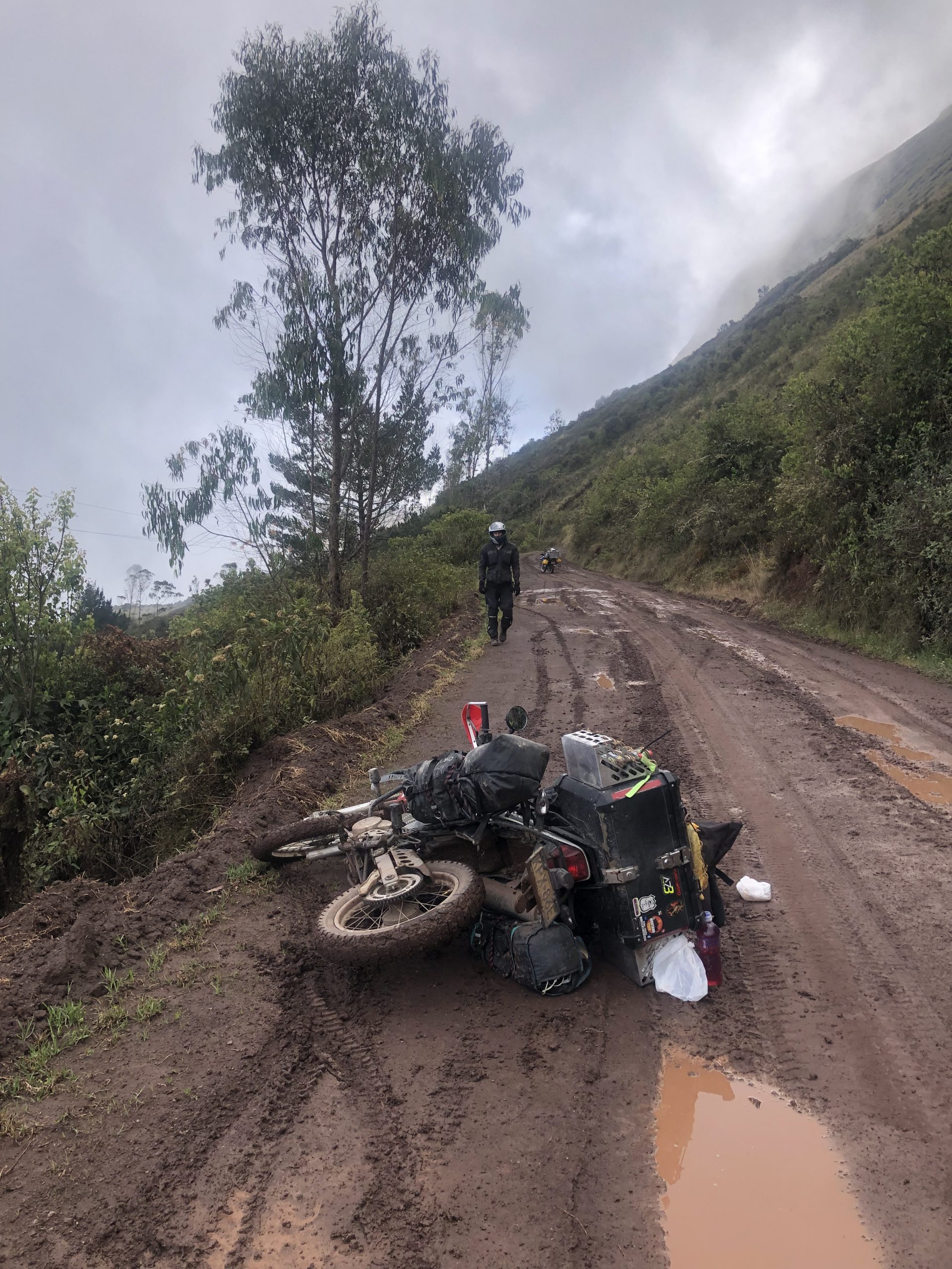 Motorrad liegt im Schlamm auf matschiger Bergstraße in Peru während Motorradreise durch Südamerika