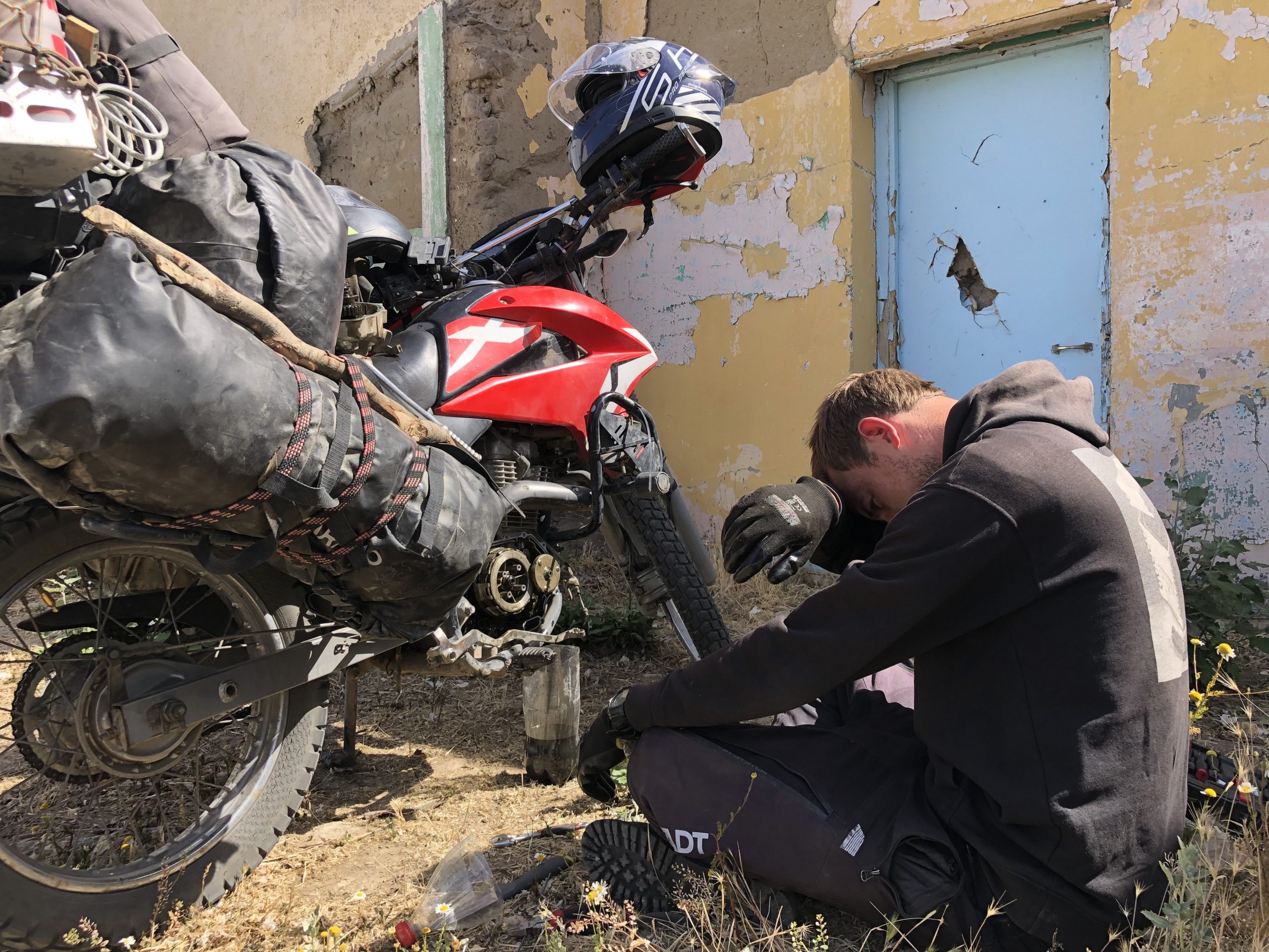 Verzweifelter Motorradfahrer mit offenem Motor seines Motorrads in Argentinien während Motorradreise durch Südamerika