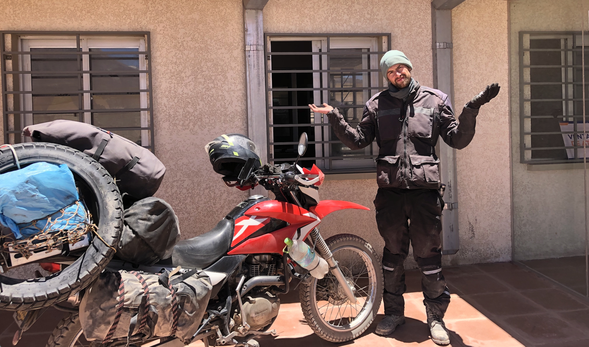 Motorradfahrer und Motorrad bei einem abgelegenen Grenzübertritt in Südamerika von Bolivien nach Chile