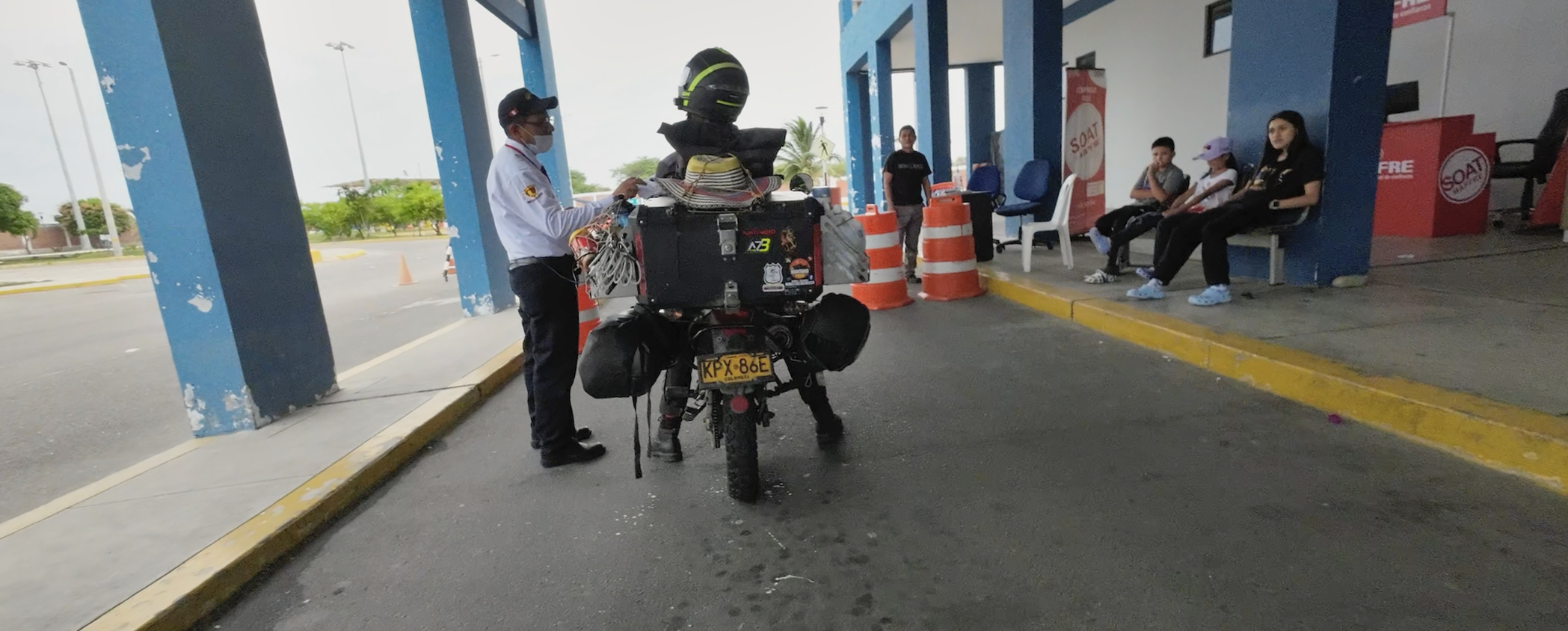 Motorradfahrerin bei der Zollkontrolle beim Grenzübertritt von Ecuador nach Peru